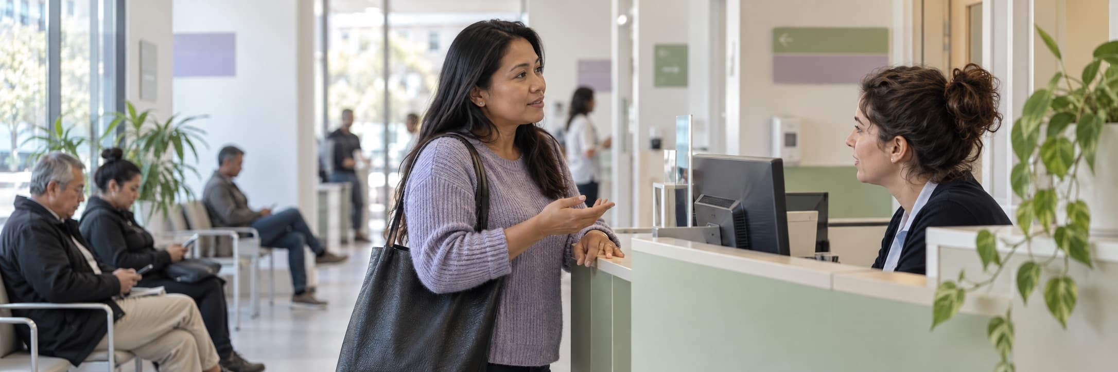 A patient speaking with a receptionist at a bright Barcelona health clinic
