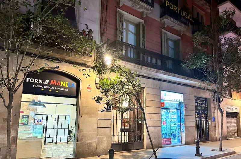 Forn de Manila’s illuminated bakery storefront on Carrer de Josep Anselm Clavé